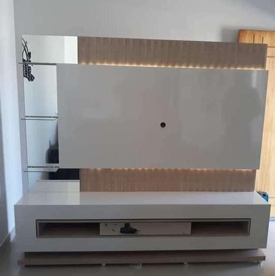 Home de sala com painel branco com espelhos ptateleiras de vidro com fitas leds acabamentos ripados
