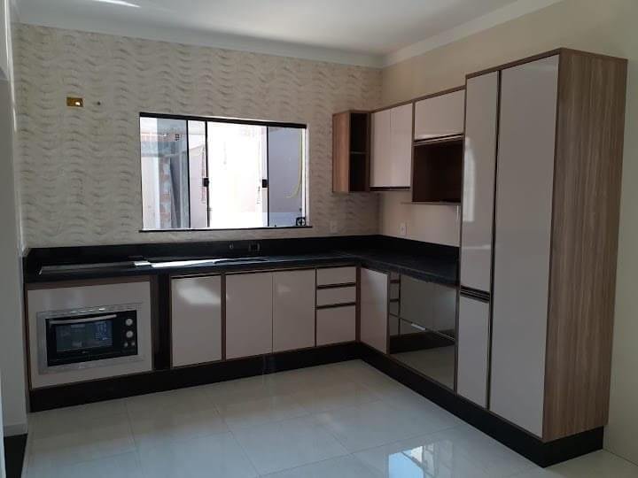 Cozinha planejada moderna com armários em MDF, acabamento em alto brilho bege com bordas amadeiradas, bancada em granito preto e eletrodomésticos embutidos. Projeto ideal para ambientes residenciais com design funcional e elegante
